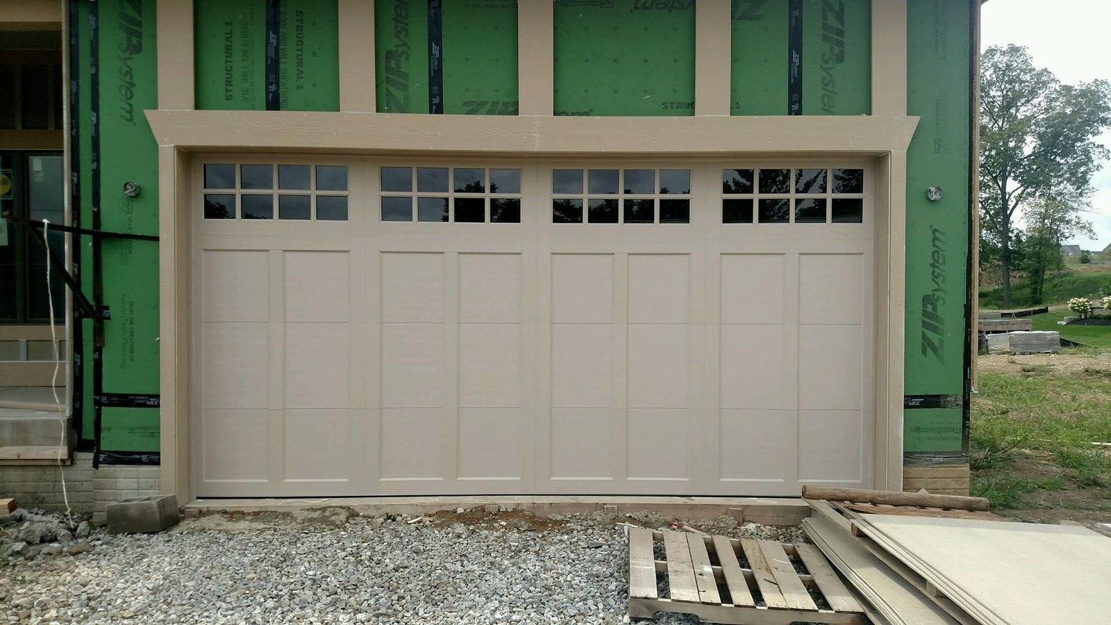 Clopay Coachman carriage house steel garage door with composite overlay and decorative hinges and handles